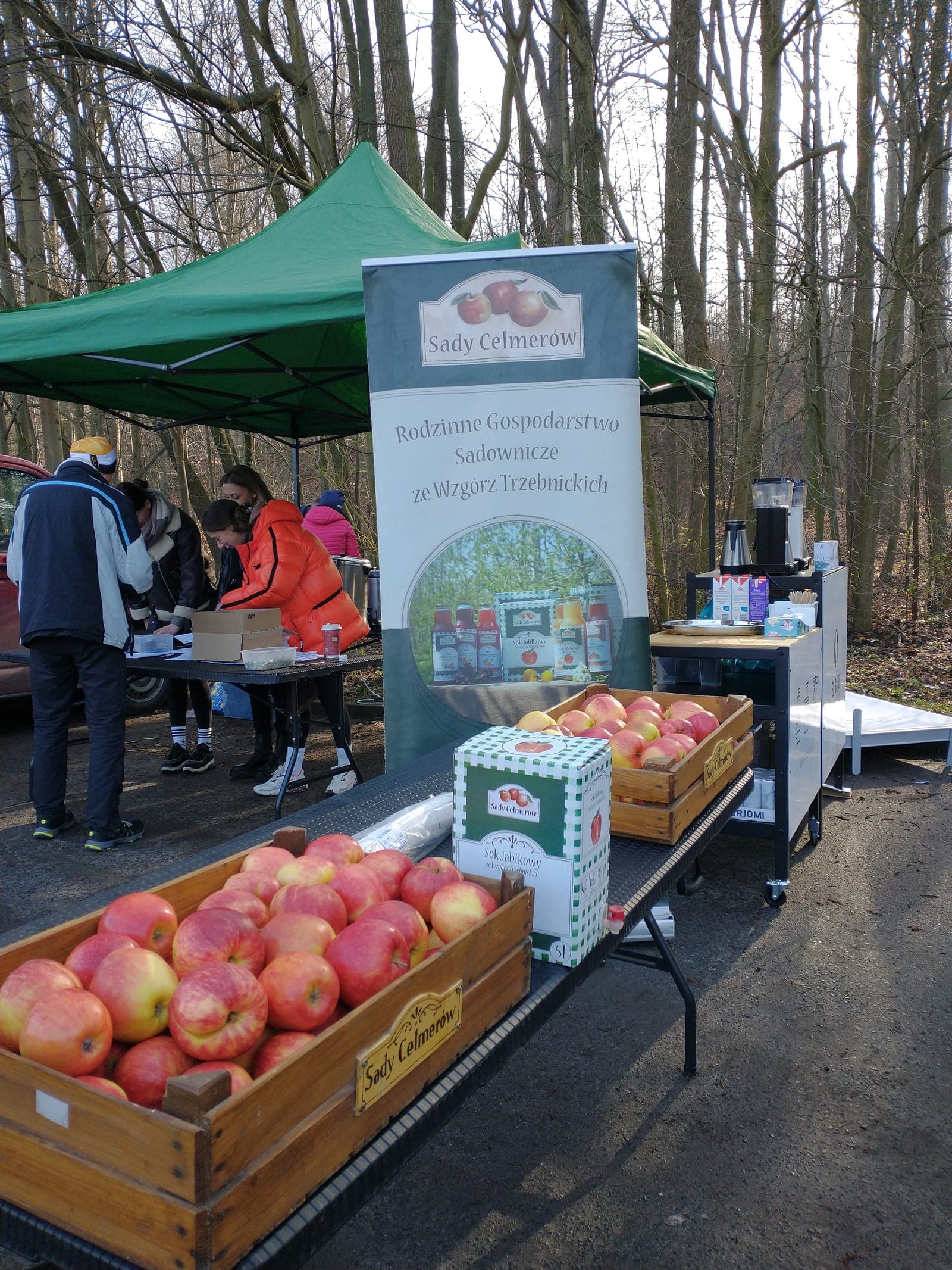 Stoisko Sadów Celmerów z banerem i jabłkami na targach