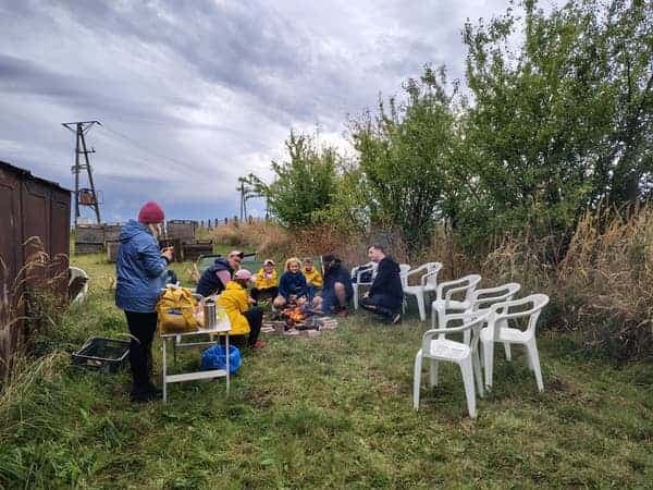 Goście Jabłkobrania odpoczywają przy ognisku w sadzie